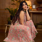 Soft peachy pink floral halter-neck dress with fresh green accents, crafted in a bias-cut silhouette that creates graceful flow and a fluid drape for an effortless summer look.