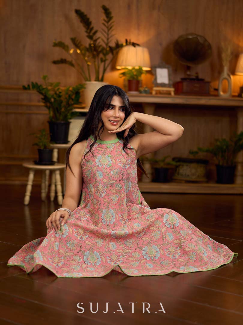 Soft peachy pink floral halter-neck dress with fresh green accents, crafted in a bias-cut silhouette that creates graceful flow and a fluid drape for an effortless summer look.