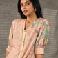 Peach Kalamkari-inspired shirt dress with soft beige accents.