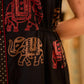 Statement black sleeveless shirt dress showcasing elephant-inspired prints and polka dots, highlighted with maroon accents.