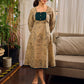 Artisanal beige Madhubani dress featuring intricate motifs, a contrasting green yoke, and refined accents.
