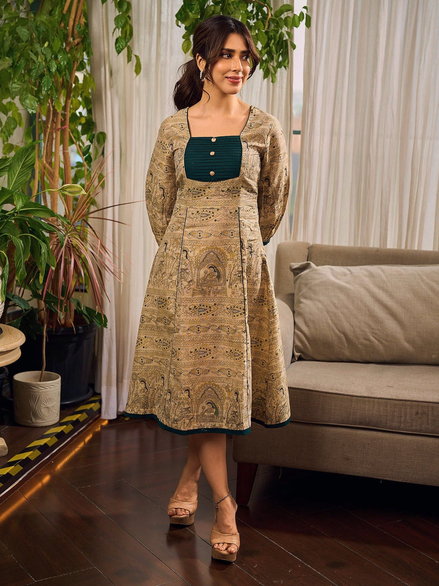 Artisanal beige Madhubani dress featuring intricate motifs, a contrasting green yoke, and refined accents.