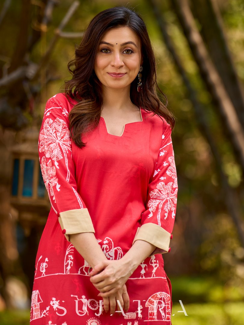 Culturally rooted red kurta displaying classic Warli designs with subtle beige touches