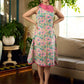 Summer pink floral sleeveless dress featuring an asymmetrical cowl collar and delicate pearl accents, creating a soft, fluid silhouette with a touch of elegant, contemporary charm.