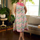 Summer pink floral sleeveless dress featuring an asymmetrical cowl collar and delicate pearl accents, creating a soft, fluid silhouette with a touch of elegant, contemporary charm.