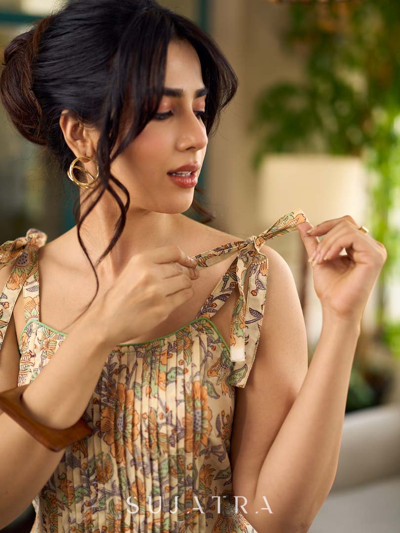 Peach floral strappy dress featuring a front tie-up bow with centre pintuck detailing, creating soft structure and a flowy, feminine silhouette perfect for effortless summer styling.