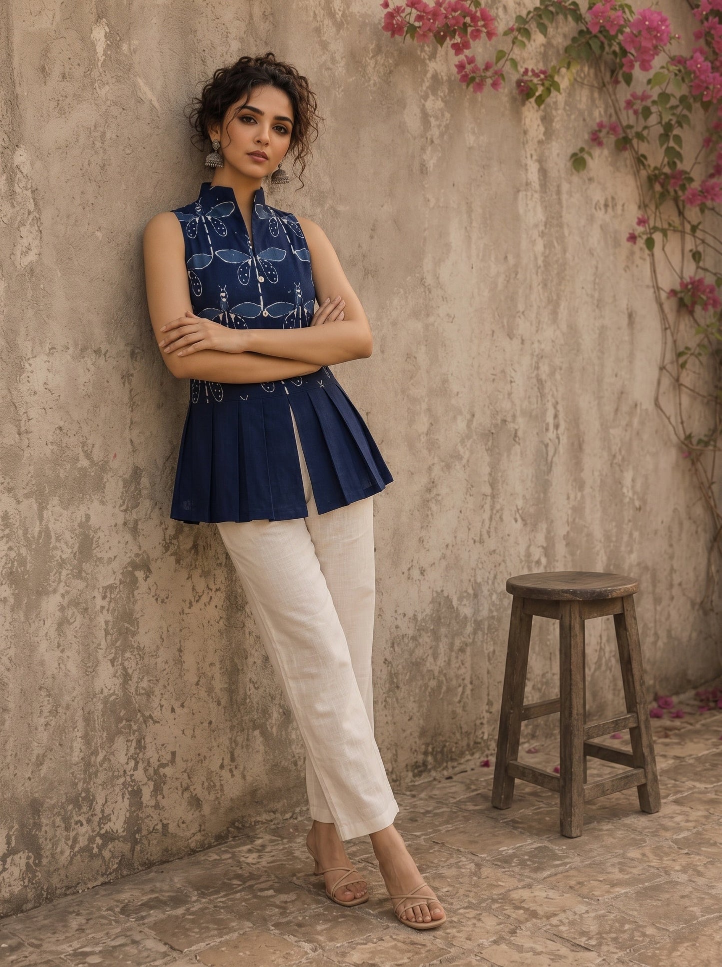 Contemporary indigo top with delicate dragonfly motifs, high folded collar, and graceful pleated hemline.