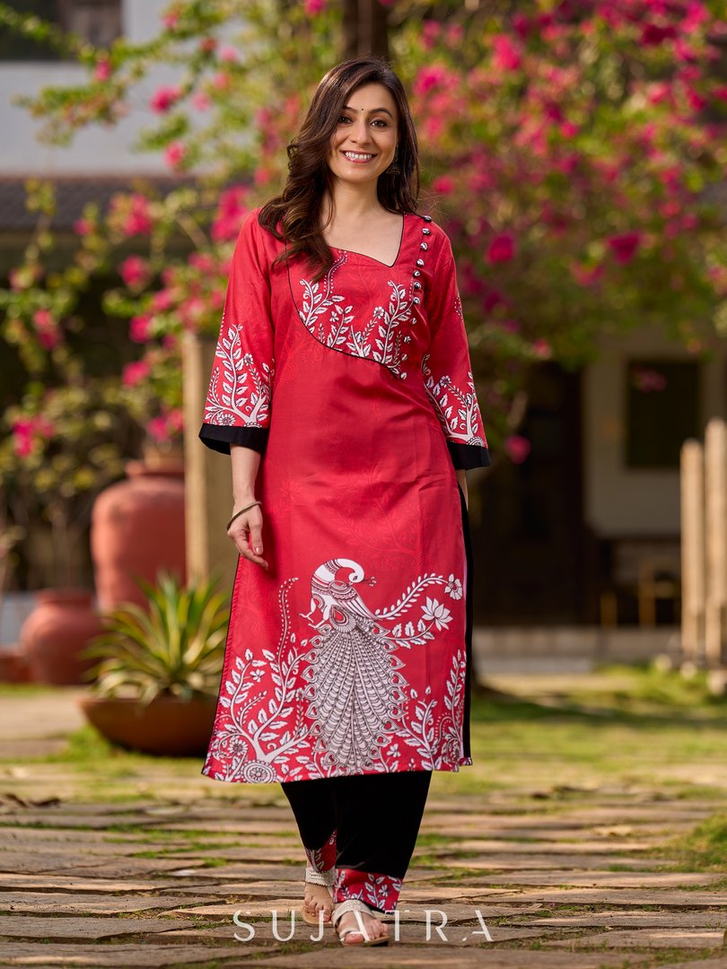 Artisanal red kurta adorned with a Kalamkari peacock motif and a striking asymmetrical neck detail