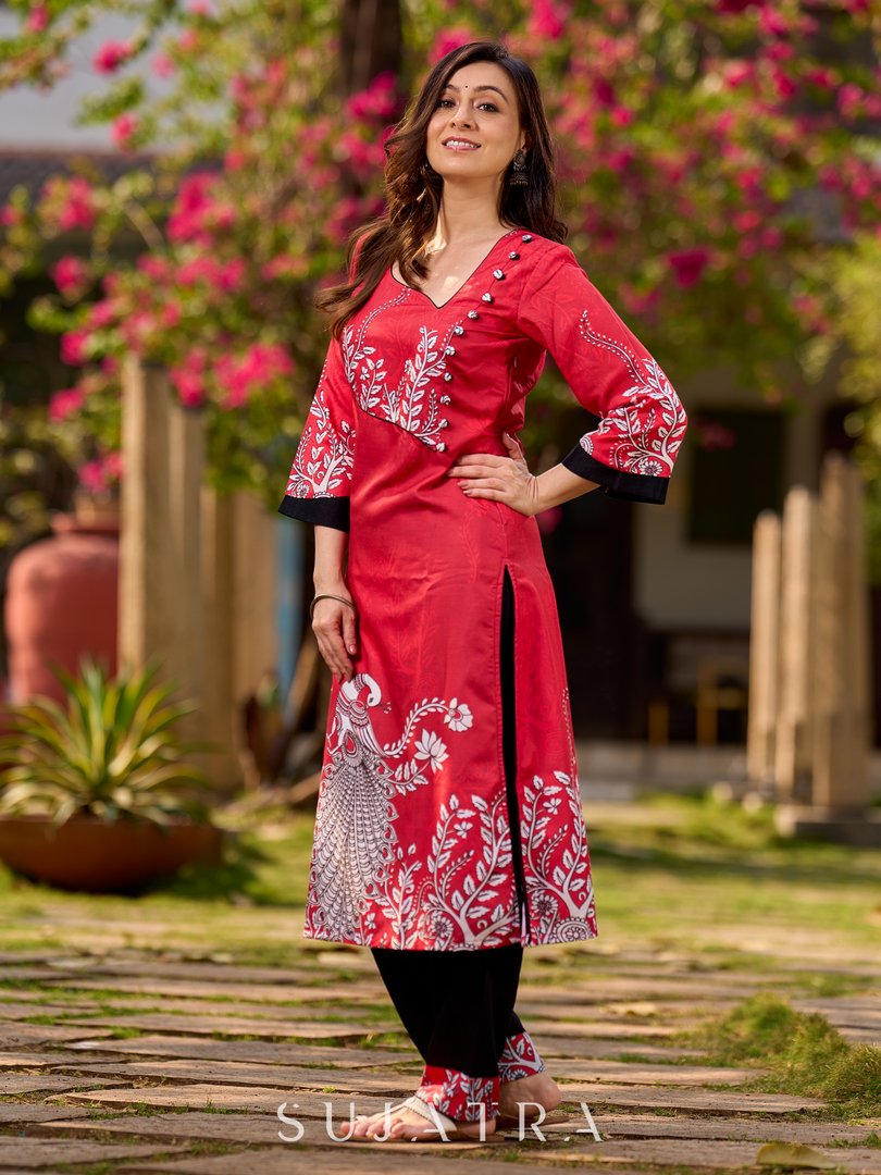 Artisanal red kurta adorned with a Kalamkari peacock motif and a striking asymmetrical neck detail