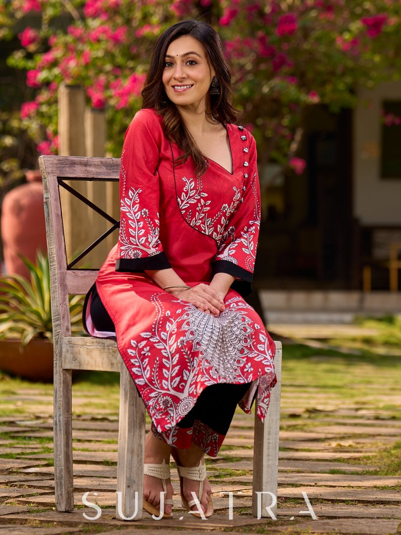 Artisanal red kurta adorned with a Kalamkari peacock motif and a striking asymmetrical neck detail