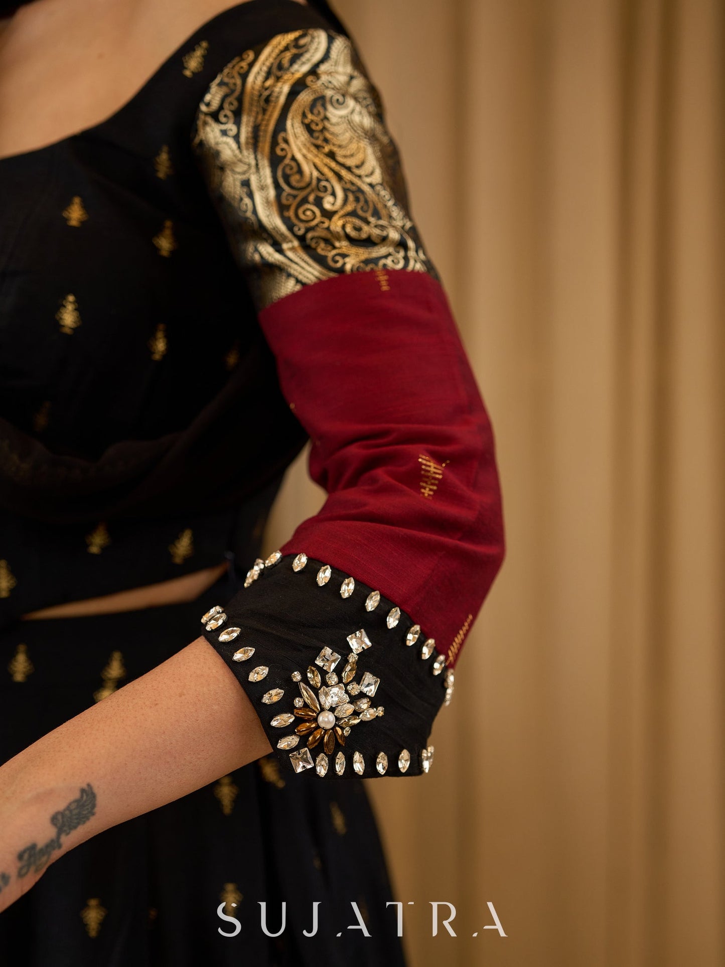 Black cotton silk & brocade lehenga paired with a sculpted corset style choli featuring intricate stonework on sleeves .