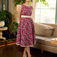 Red Gulmohar floral-printed sleeveless summer dress featuring off-white accents and scalloped lace detailing at the waist, creating a breezy, feminine silhouette perfect for warm, sunlit days.