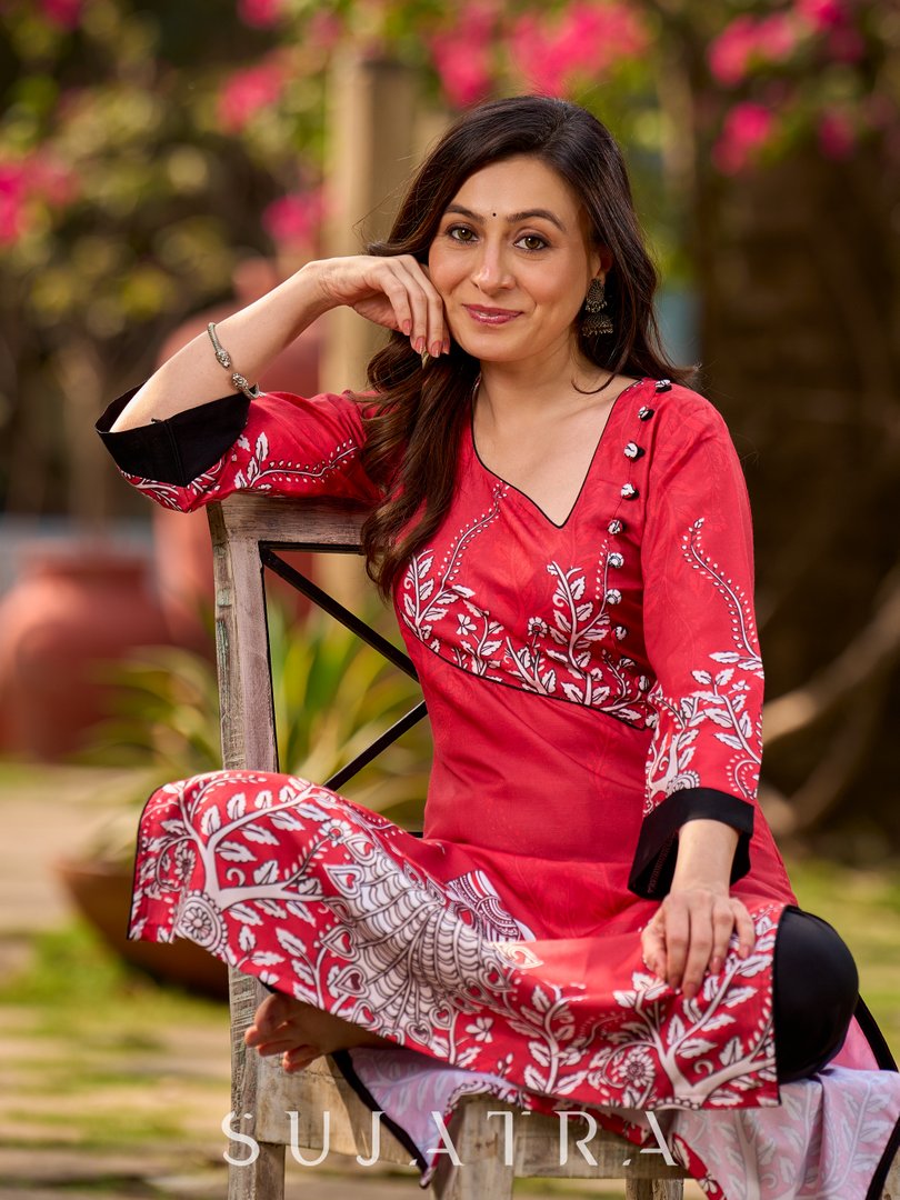 Artisanal red kurta adorned with a Kalamkari peacock motif and a striking asymmetrical neck detail