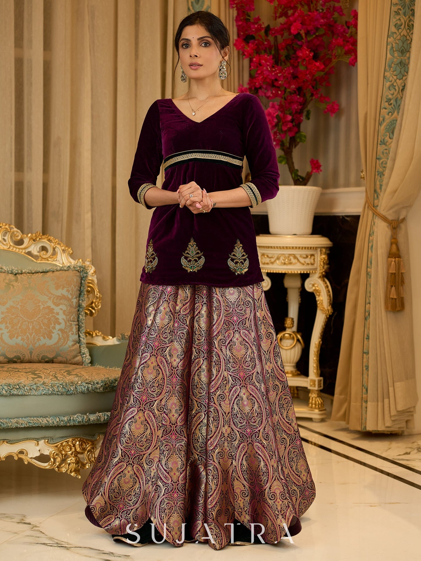 Royal Wine Lehenga with a scalloped hem and a luxurious velvet choli with Zardosi work .