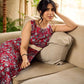 Red Gulmohar floral-printed sleeveless summer dress featuring off-white accents and scalloped lace detailing at the waist, creating a breezy, feminine silhouette perfect for warm, sunlit days.