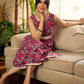 Red Gulmohar floral-printed sleeveless summer dress featuring off-white accents and scalloped lace detailing at the waist, creating a breezy, feminine silhouette perfect for warm, sunlit days.
