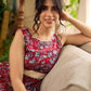 Red Gulmohar floral-printed sleeveless summer dress featuring off-white accents and scalloped lace detailing at the waist, creating a breezy, feminine silhouette perfect for warm, sunlit days.