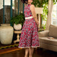 Red Gulmohar floral-printed sleeveless summer dress featuring off-white accents and scalloped lace detailing at the waist, creating a breezy, feminine silhouette perfect for warm, sunlit days.