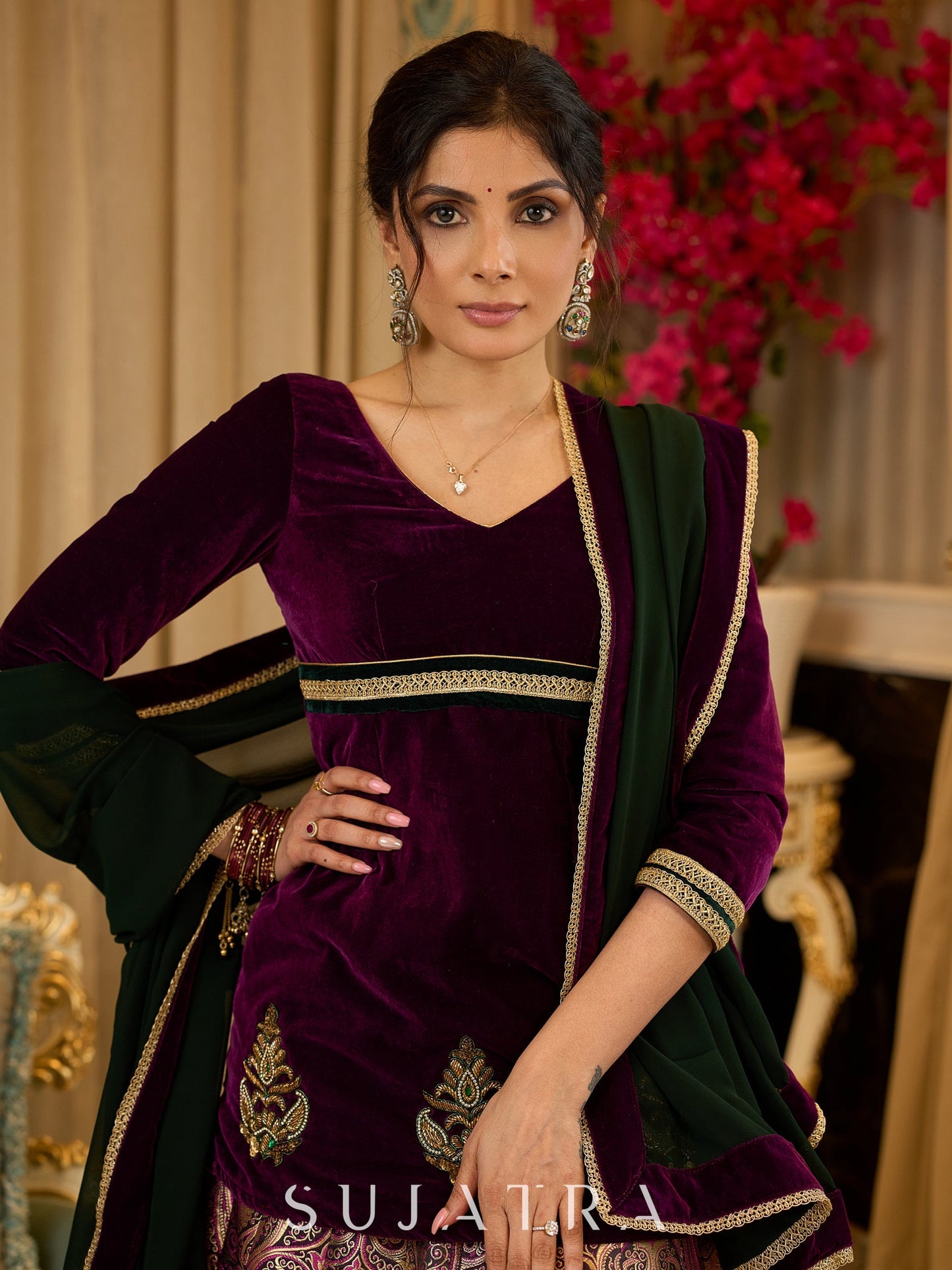 Royal Wine Lehenga with a scalloped hem and a luxurious velvet choli with Zardosi work .