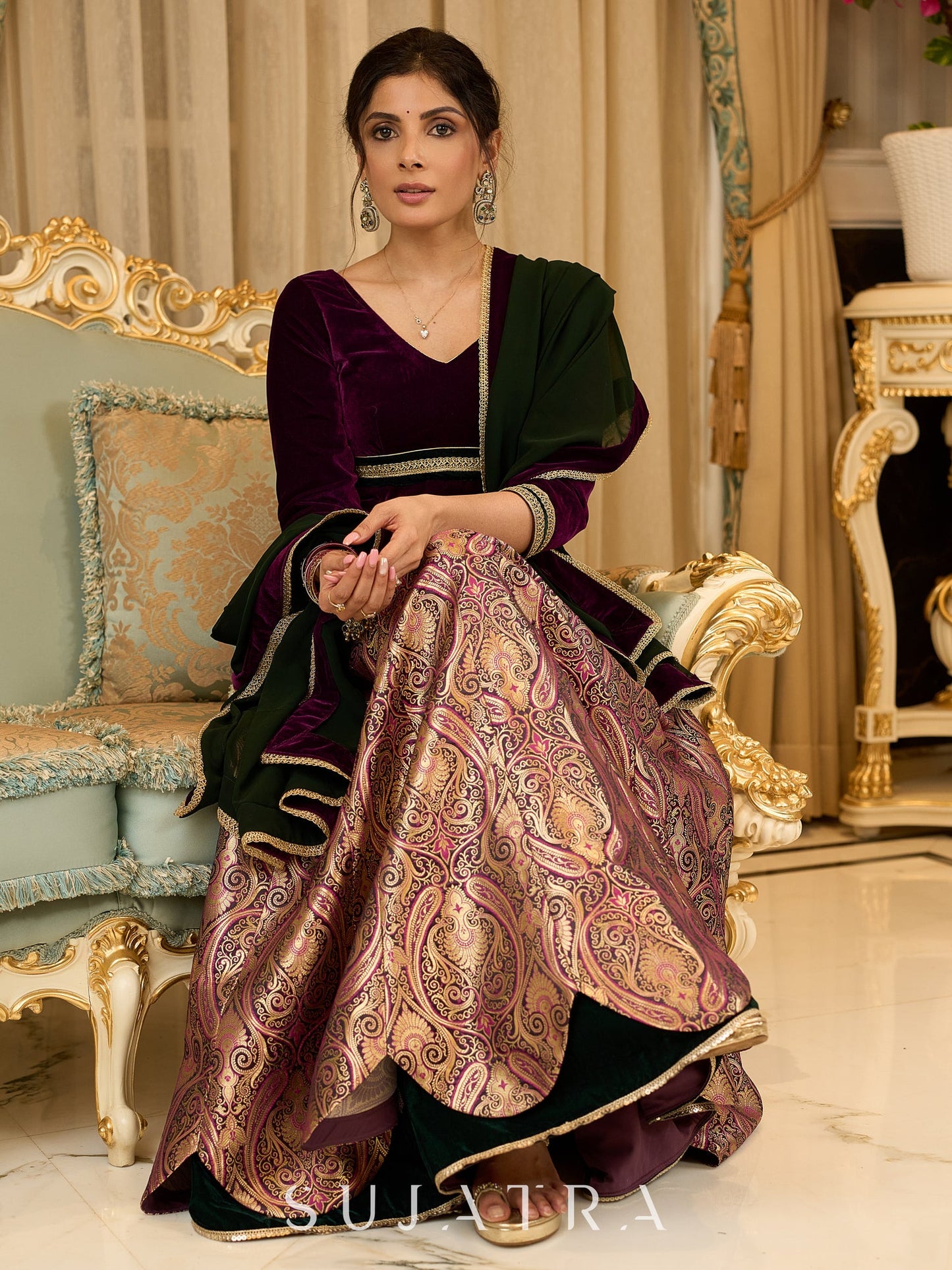 Royal Wine Lehenga with a scalloped hem and a luxurious velvet choli with Zardosi work .