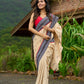 Beige cotton saree enriched with traditional Ikat border and Jamdani accents