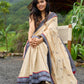 Beige cotton saree enriched with traditional Ikat border and Jamdani accents