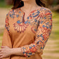 Elegant mustard kurta featuring Kalamkari print in an asymmetrical layout