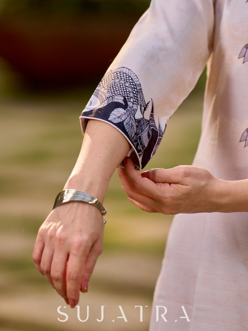 Artisanal cream kurta showcasing Madhubani fish and peacock motifs enhanced with bold black accents