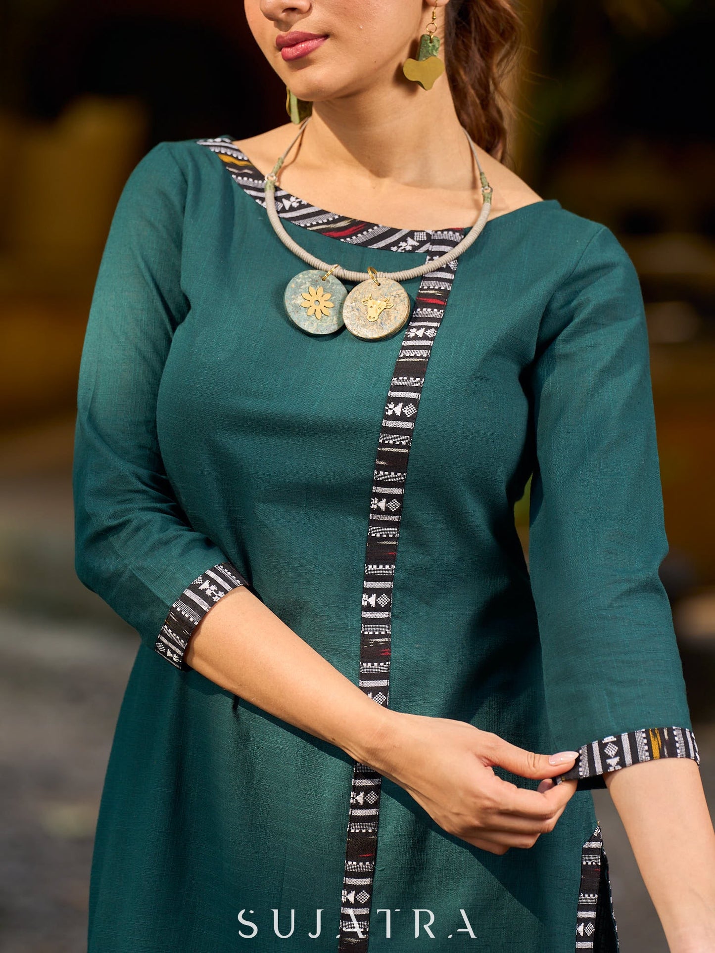 bottle green solid kurta with a refined ajrakh edging.