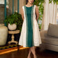 Bottle green and off-white hand block printed sleeveless dress with a block printed geometric panel, pearl embellishments, and refined accents for a contemporary artisanal look.