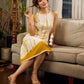Sunlit ivory tie-dye dress with mustard accents and playful tassel shoulder detailing.