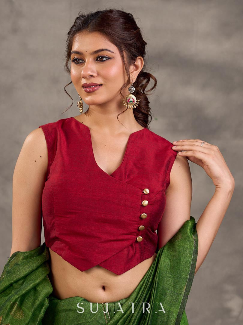 Blouse sans manches en mélange de coton et soie couleur bordeaux, croisée devant de manière asymétrique et agrémentée de boutons dorés