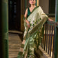 Muted Green Tussar Silk Saree with Delicate Floral Artwork and Classic Border