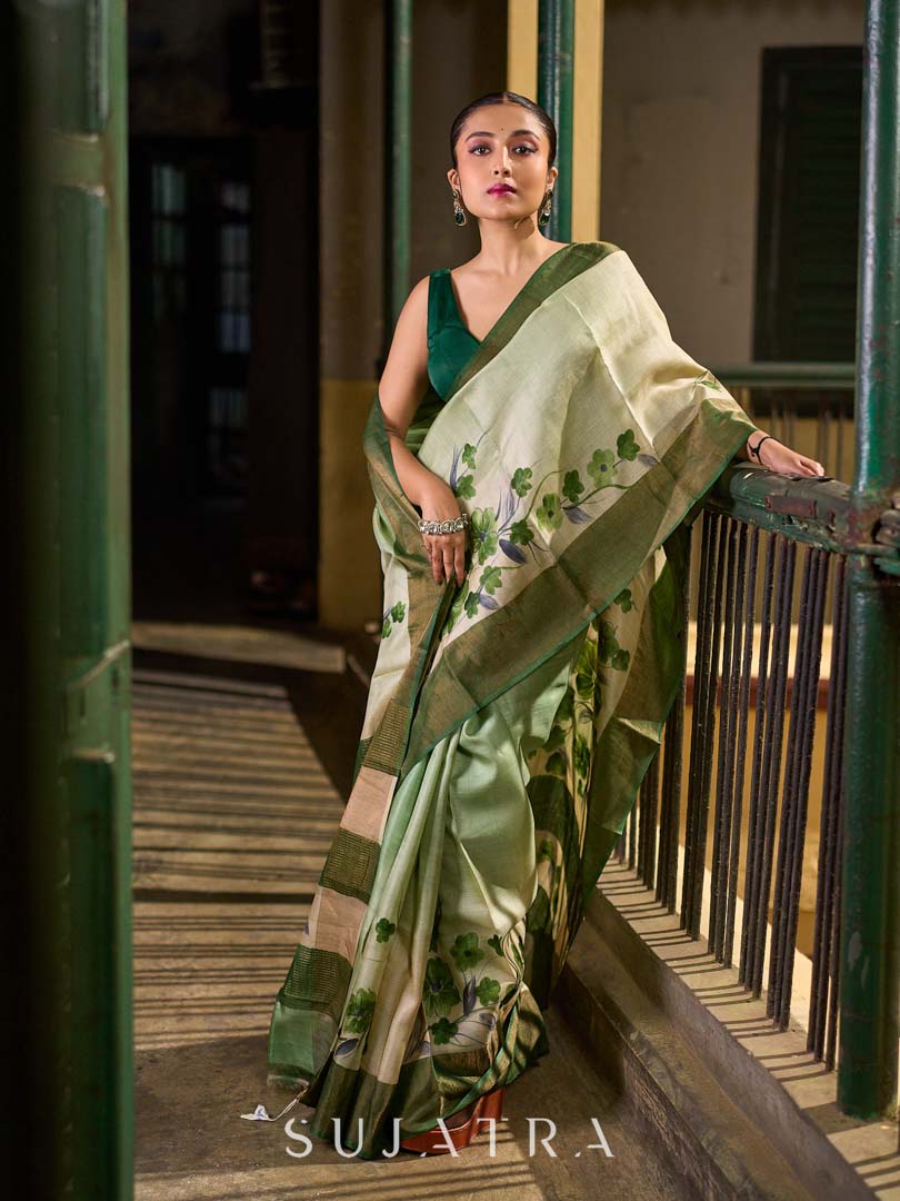 Muted Green Tussar Silk Saree with Delicate Floral Artwork and Classic Border