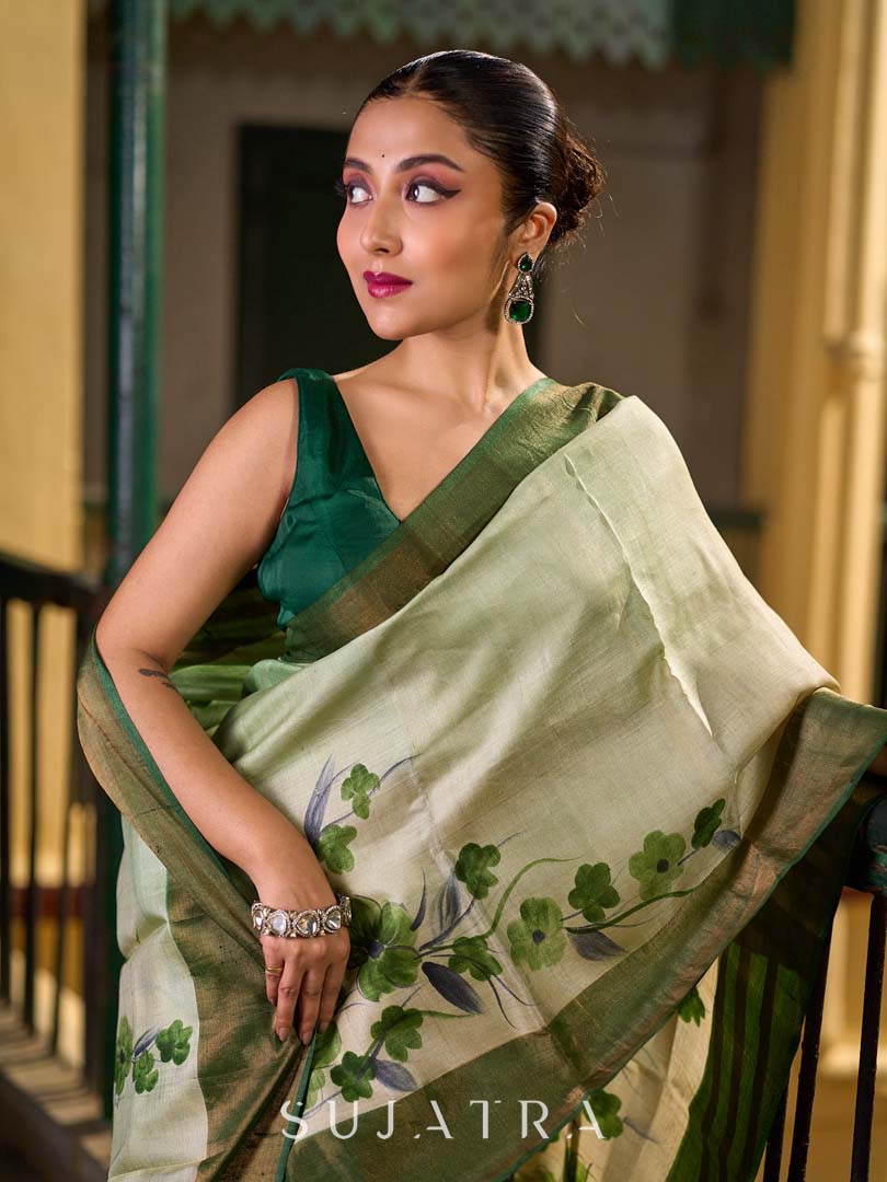 Muted Green Tussar Silk Saree with Delicate Floral Artwork and Classic Border