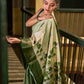 Muted Green Tussar Silk Saree with Delicate Floral Artwork and Classic Border