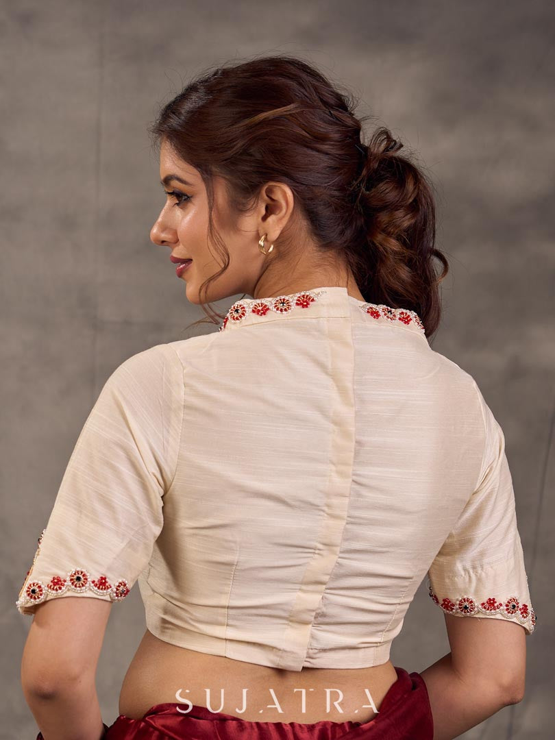 Blouse en coton et soie crème avec encolure et manches brodées de motifs floraux colorés