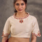 Blouse en coton et soie crème avec encolure et manches brodées de motifs floraux colorés