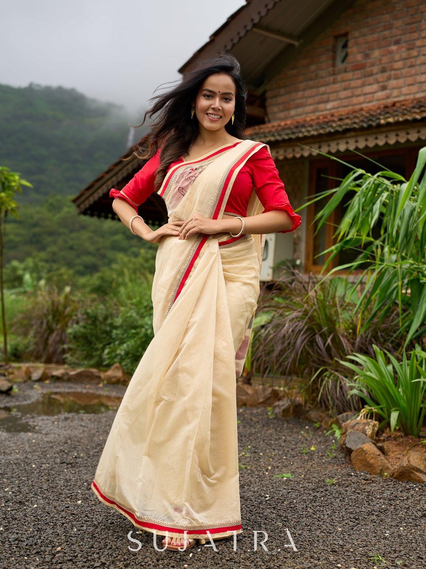 Elegant cream chanderi saree with subtle red border, featuring hand-painted Durga art