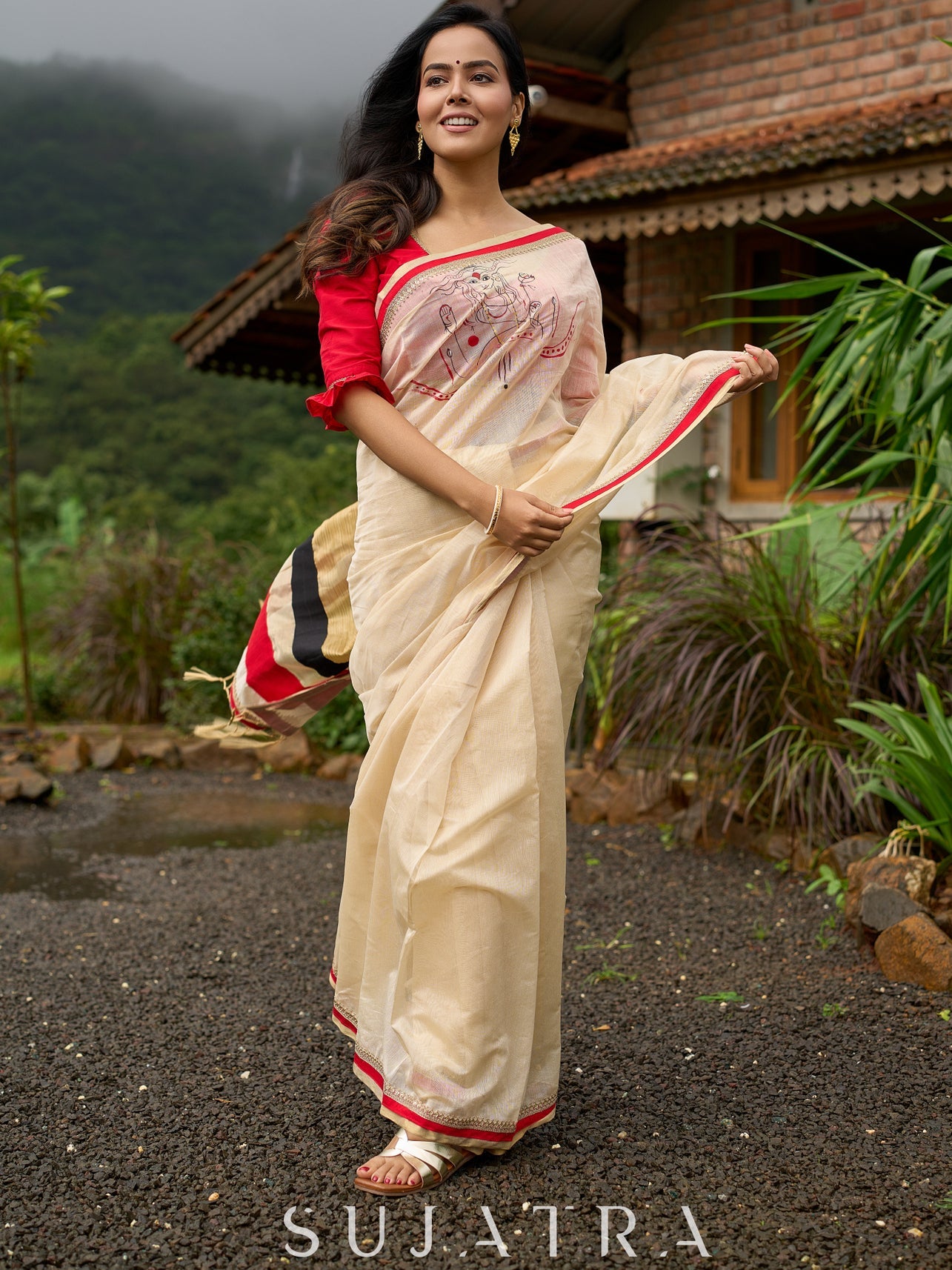 Elegant cream chanderi saree with subtle red border, featuring hand-painted Durga art