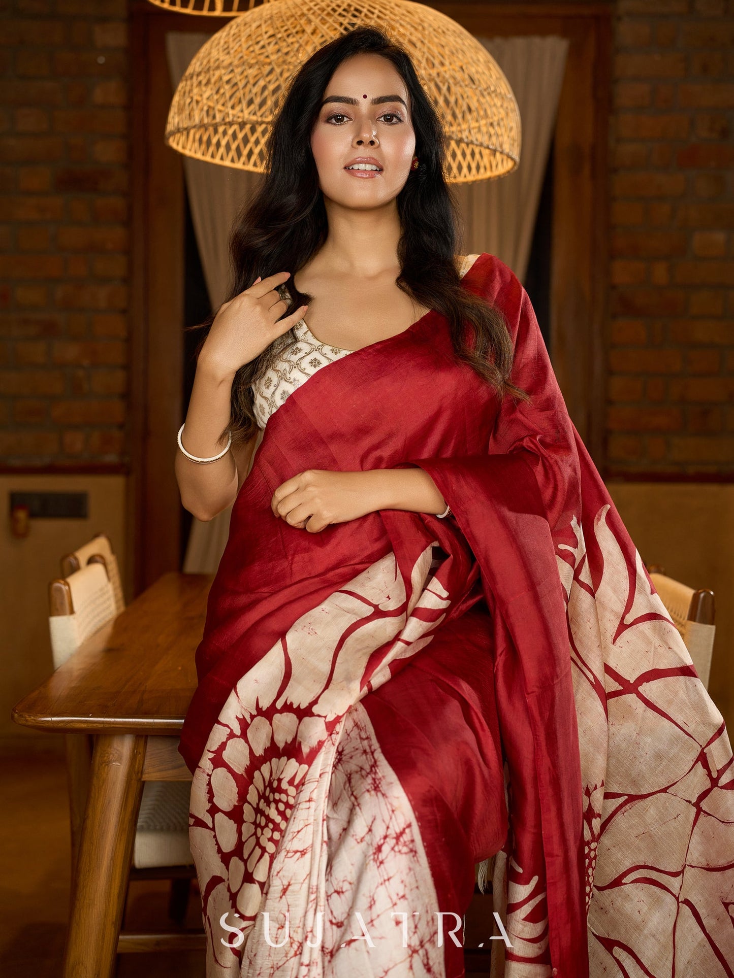 Artisanal crimson silk saree featuring heritage batik floral designs