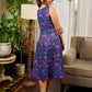 Enchanting purple panel dress featuring vibrant magenta floral prints, a sleeveless silhouette, and a graceful fit-and-flare design for timeless elegance.