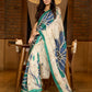 Classic ivory pure silk saree highlighted by teal borders and hand batik artistry