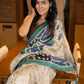 Classic ivory pure silk saree highlighted by teal borders and hand batik artistry