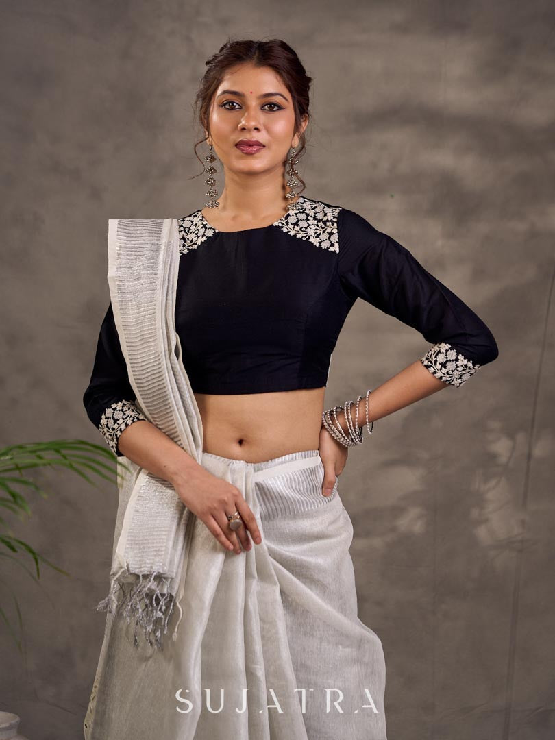 Blouse en soie et coton noir à manches 3/4 avec détails en dentelle brodée florale blanche sur l'encolure et les poignets
