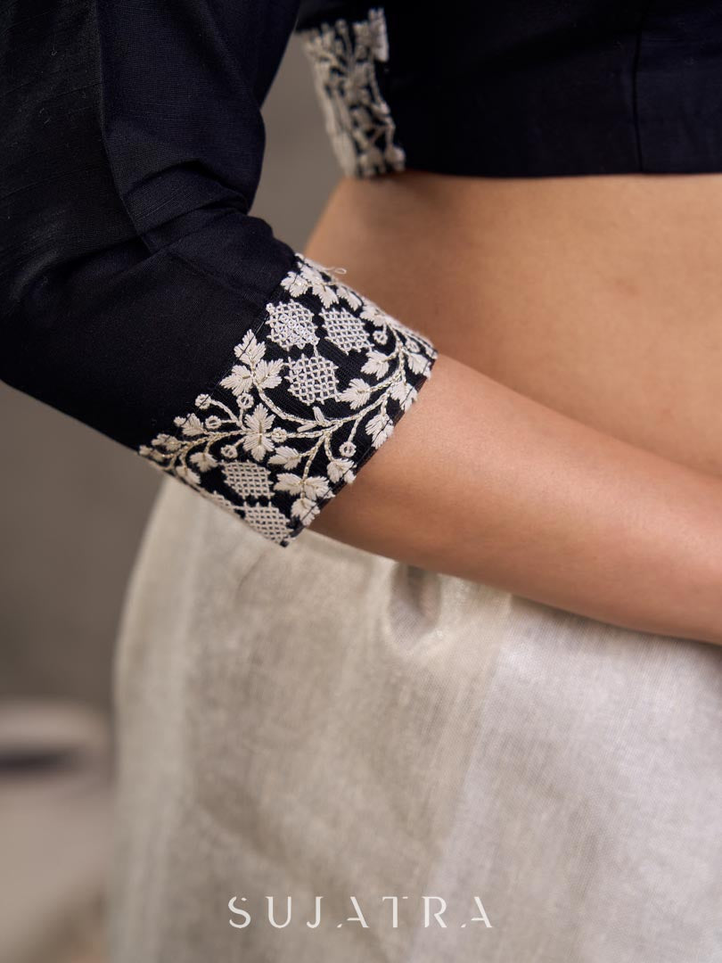 Blouse en soie et coton noir à manches 3/4 avec détails en dentelle brodée florale blanche sur l'encolure et les poignets