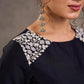 Blouse en soie et coton noir à manches 3/4 avec détails en dentelle brodée florale blanche sur l'encolure et les poignets