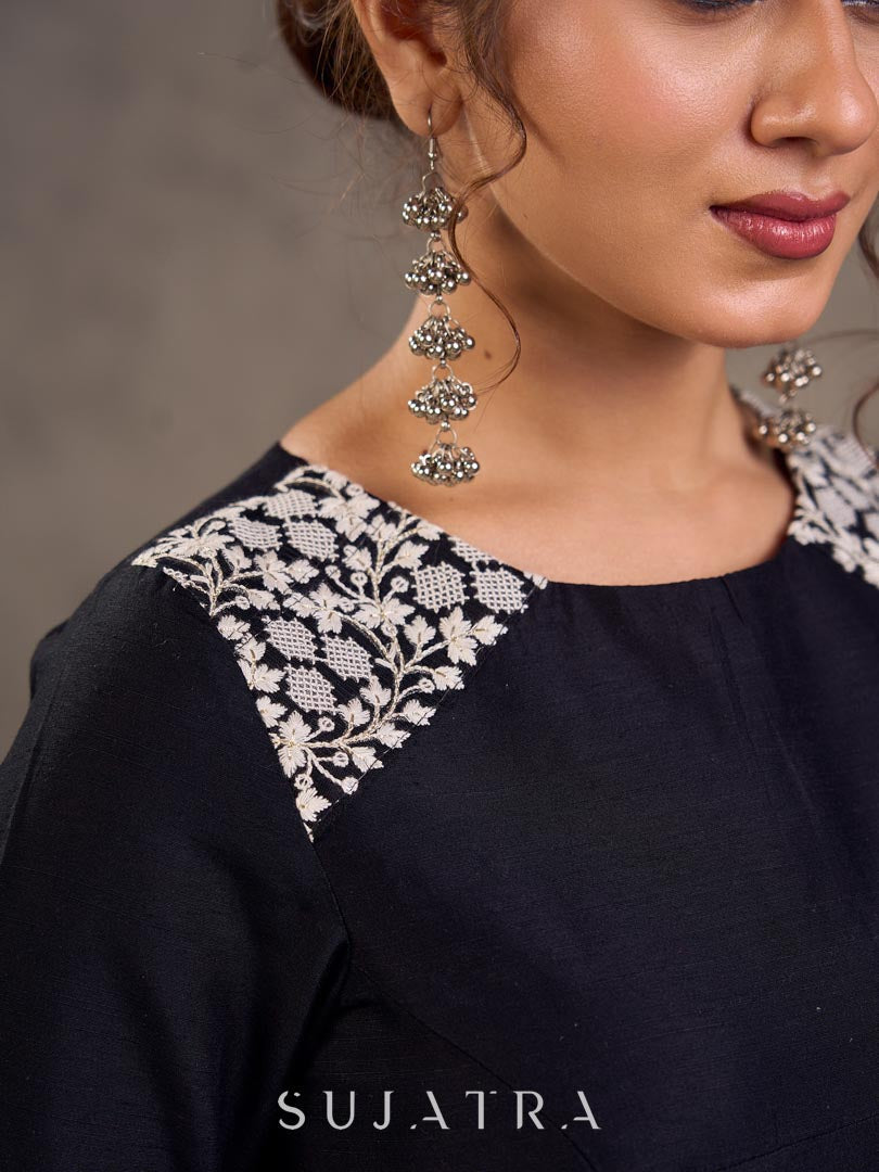 Blouse en soie et coton noir à manches 3/4 avec détails en dentelle brodée florale blanche sur l'encolure et les poignets