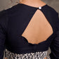 Blouse en soie et coton noir à manches 3/4 avec détails en dentelle brodée florale blanche sur l'encolure et les poignets