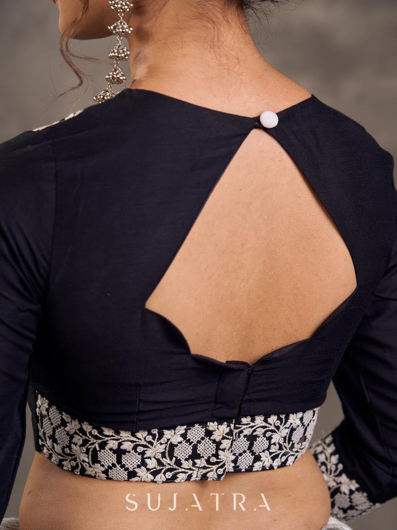 Blouse en soie et coton noir à manches 3/4 avec détails en dentelle brodée florale blanche sur l'encolure et les poignets